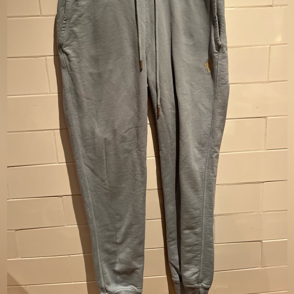 Blue OVO sweatpants jogger style, with gold stitching.